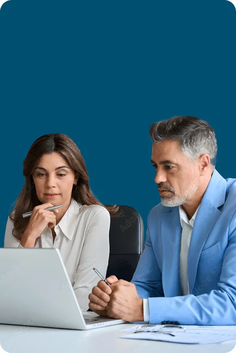 Two professionals thoughtfully reviewing content on a laptop together.